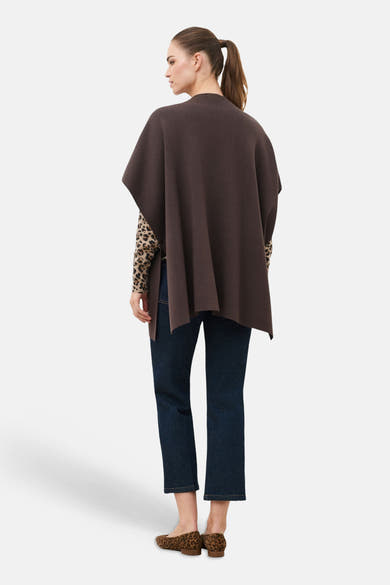 Brown knit gilet by CAROLL, back view, with leopard print sleeves and jeans, flat shoes, side profile