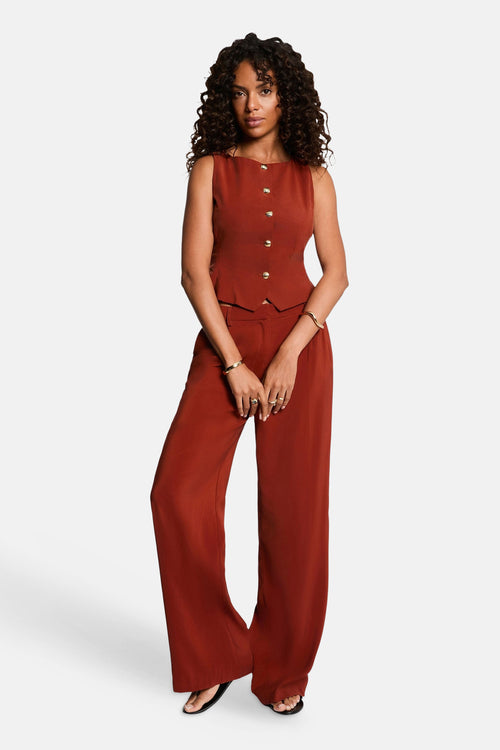 Orange sleeveless gilet with front buttons by Morgan de Toi, worn with matching wide-leg trousers, full-length front view