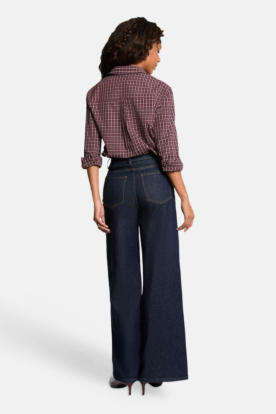 Red long-sleeve blouse with white grid pattern, back view, worn with dark denim wide-leg jeans and pointed heels