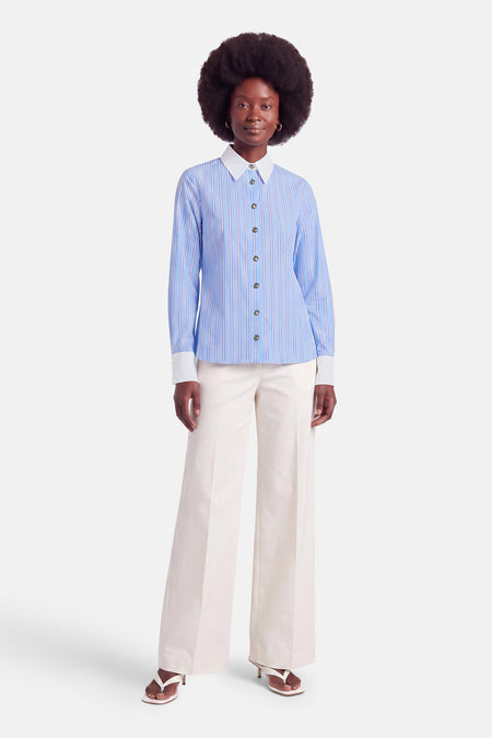 Chemise bleue à rayures fines et col blanc par Morgan de Toi, boutonnée, vue de face sur modèle en pantalon blanc