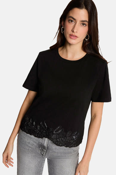 Black short-sleeve t-shirt with lace hem detail, worn with gray jeans, front view