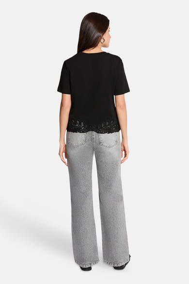 Black short-sleeve t-shirt with lace trim hem, back view, worn with gray wide-leg jeans
