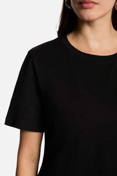 Black short-sleeve t-shirt with ribbed crew neckline, close-up front view on model wearing hoop earrings