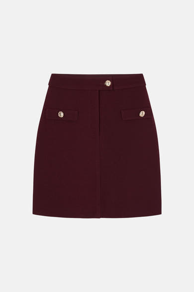 Burgundy A-line skirt with front pockets and gold-tone buttons, front view, textured fabric, casual style
