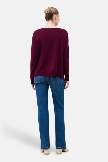Vue de dos d’un pull col rond mauve CAROLL porté avec un jean bleu.