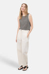 Beige wide-leg trousers with front pockets and buttoned cuffs, worn with a striped knit top and black sandals, full-length front view
