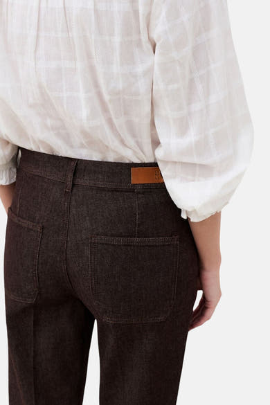Vue arrière d’un pantalon 5 poches brun CAROLL porté avec un chemisier blanc à manches longues.