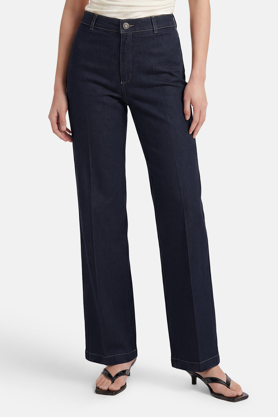 Dark blue wide-leg denim jeans by MIRA, featuring a high waist, clean stitching, and cuffed hems, shown on model with black heels.
