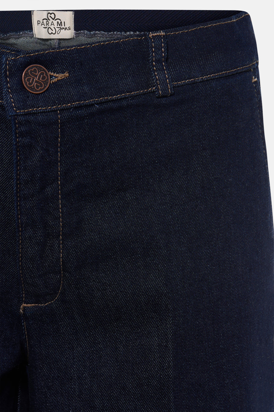 Dark blue denim jeans by Parami, featuring copper button and contrast stitching, close-up front view