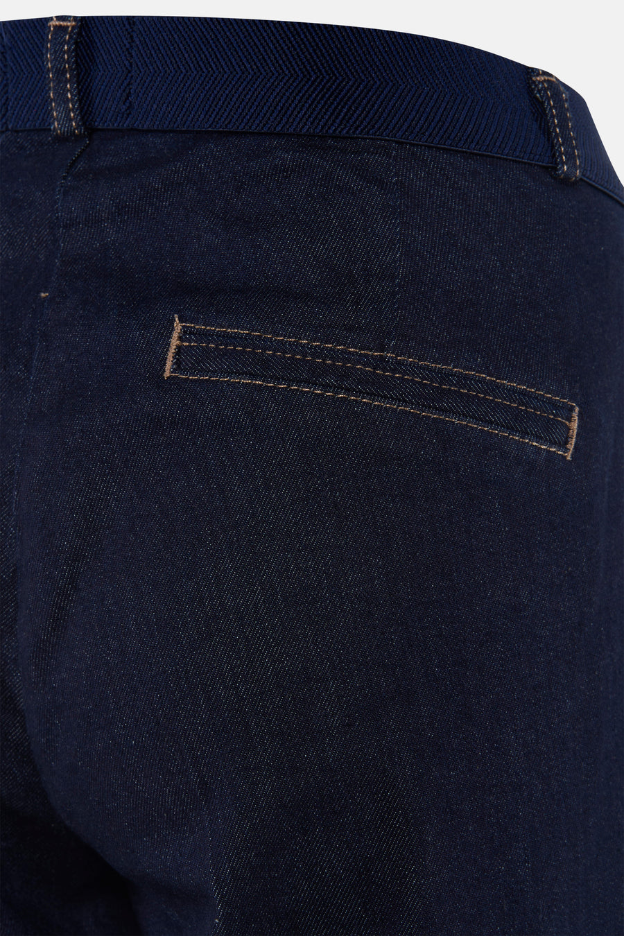 Dark blue denim jeans by MIRA, back view showing textured fabric and tan stitching on pocket detail