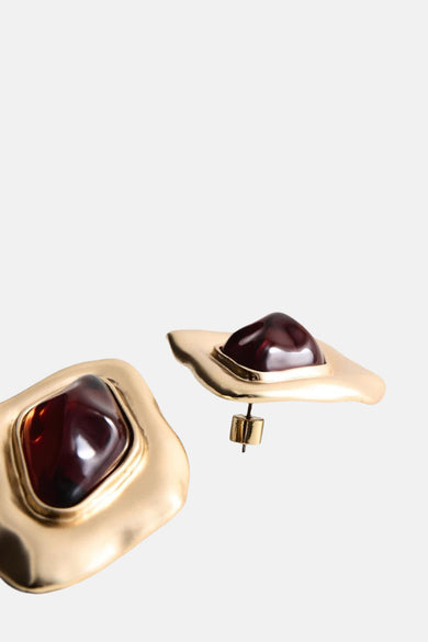 Multikleurige oorbellen van MANGO, met donkerrode stenen en gouden monturen.