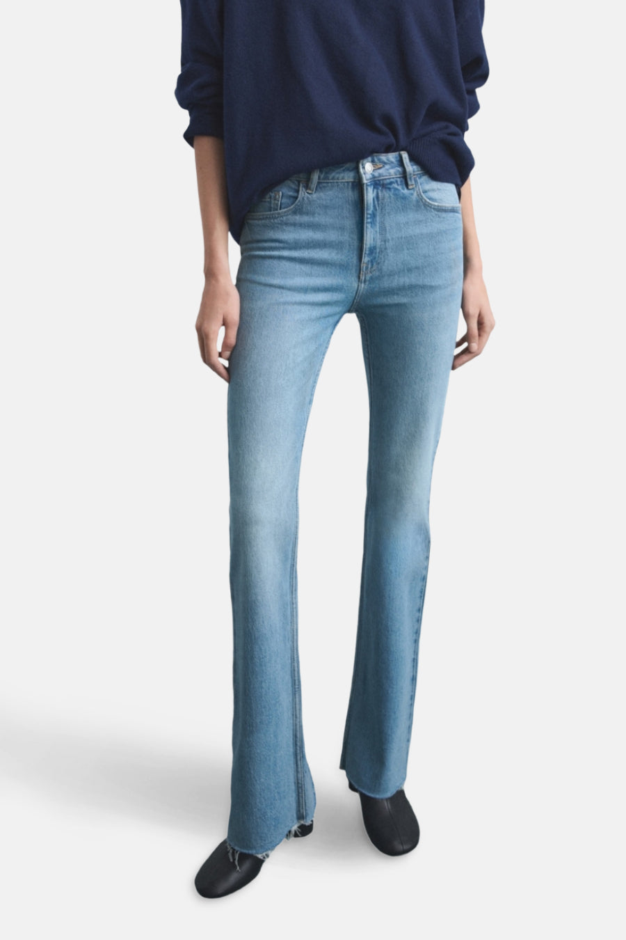 Jean évasé en denim bleu clair de MANGO, porté avec un pull bleu marine.