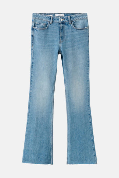 Jean évasé en denim bleu clair de MANGO, coupe droite, ourlet brut.