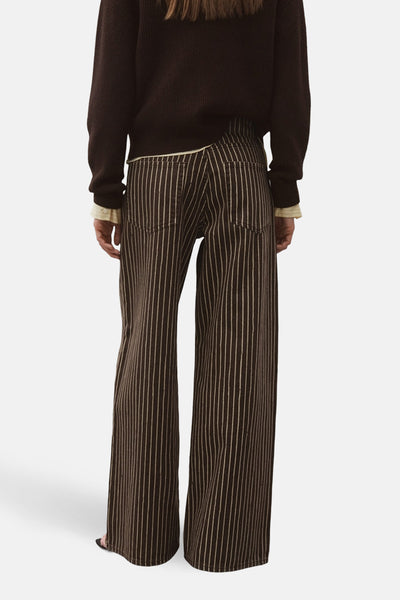 Jeans coloré brun de MANGO, à rayures verticales blanches, coupe évasée et poches arrière.