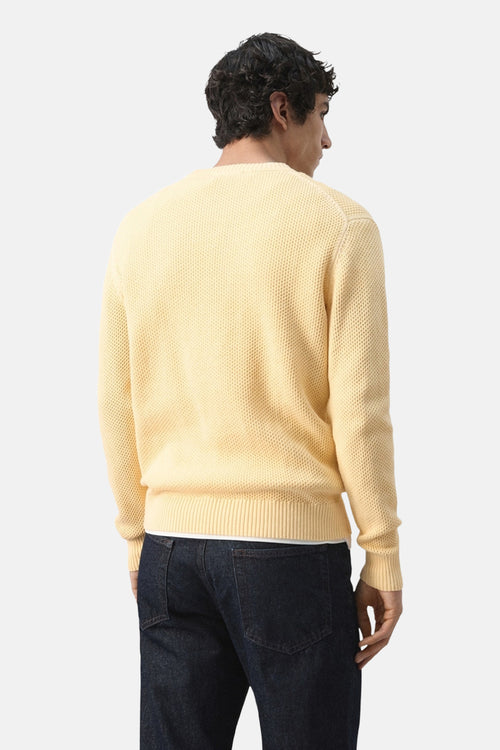 Pull ras du cou jaune MANGO, texture gaufrée, porté avec un jean bleu foncé, vue de dos.