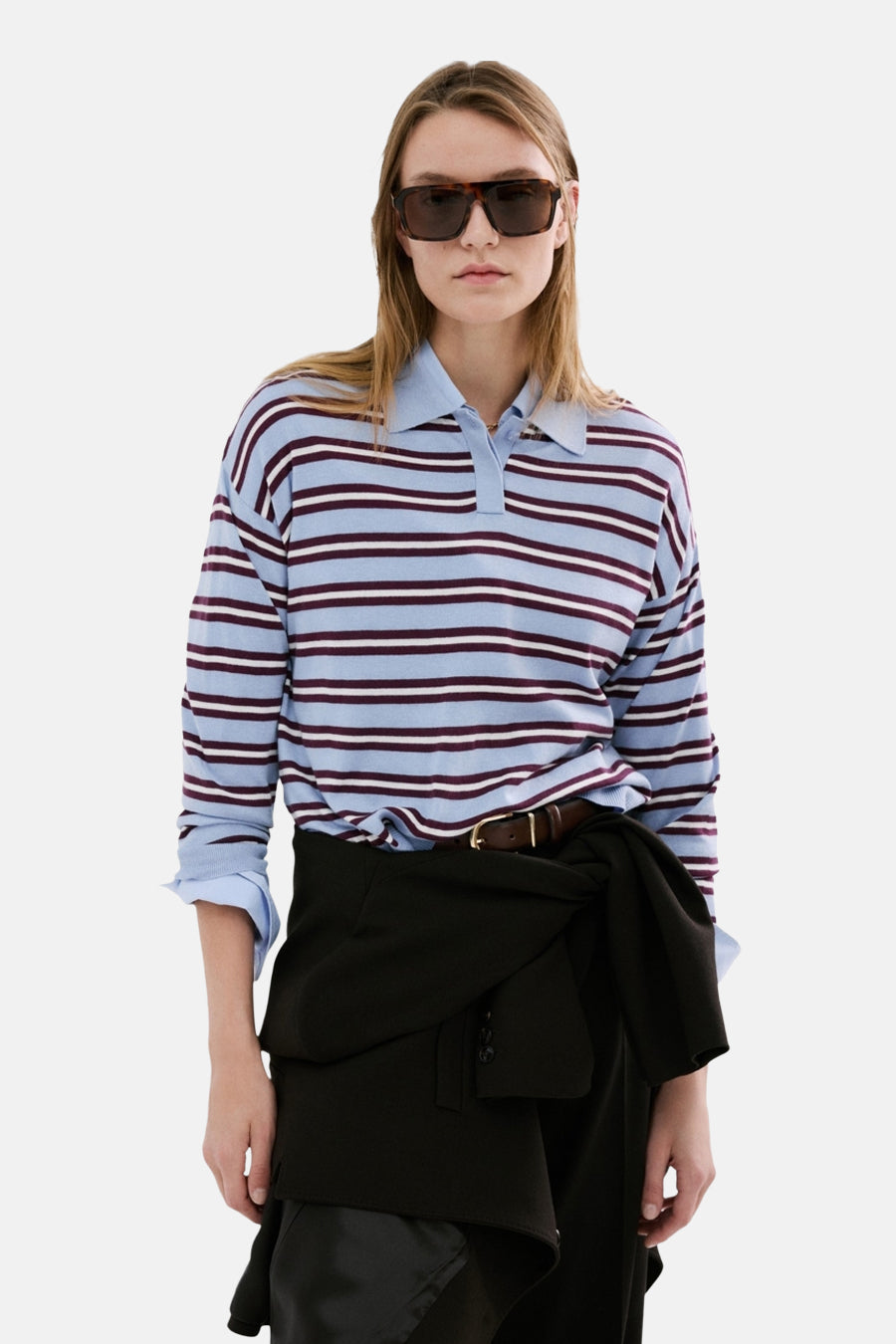 Multikleurige rondehals trui van MANGO, met blauwe en bordeauxrode strepen, gedragen met een zwarte broek.