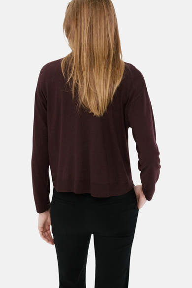Pull col rond bordeaux de MANGO, à manches longues, porté avec un pantalon noir.
