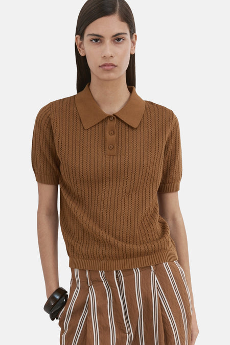 Bruin POLO van MANGO, korte mouwen en ajourstructuur, gedragen met een bruin-witte gestreepte broek, achterzicht.