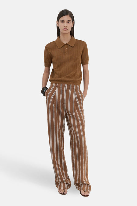Bruin gebreid poloshirt van MANGO, met klassieke kraag en korte mouwen, gedragen met een gestreepte broek.