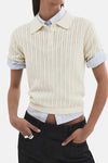 Beige polo van MANGO, gedragen met een licht T-shirt en een effen donkere broek, achterzicht.