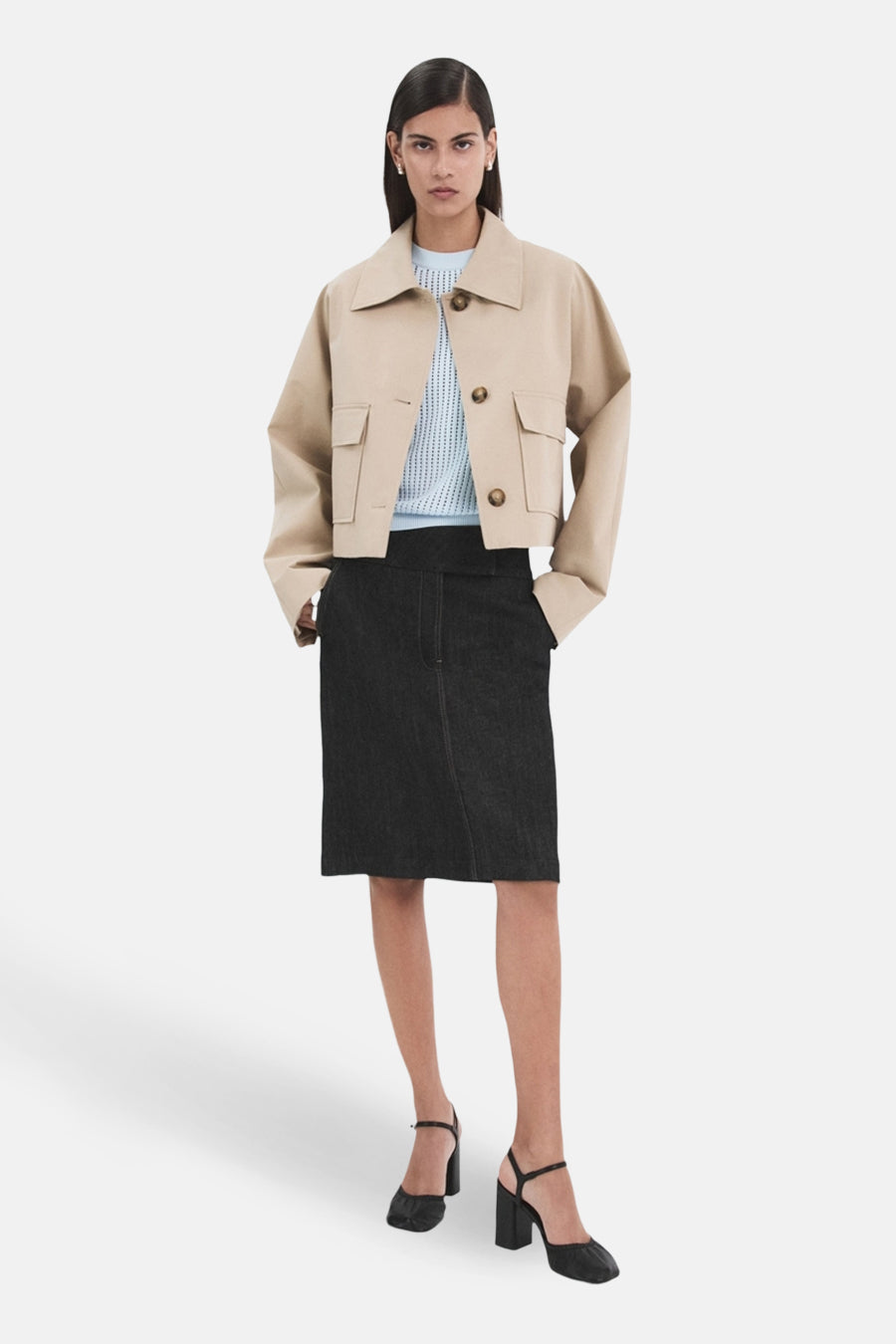 Blauwe trui met ronde hals van MANGO, gedragen met een beige jas met zakken en een zwarte kokerrok.