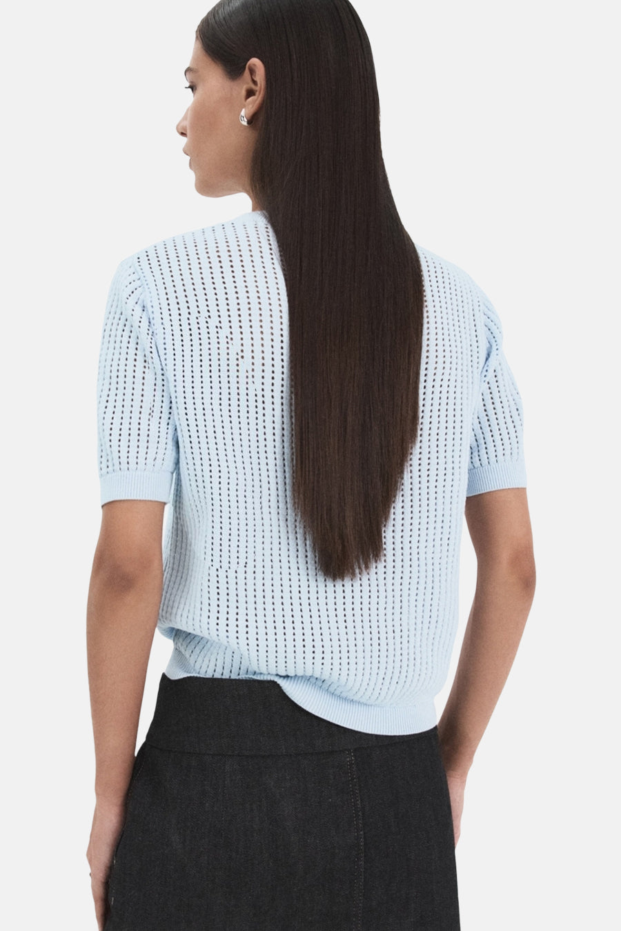 Pull à col rond bleu en maille ajourée de MANGO, porté avec une jupe foncée, vue arrière.

