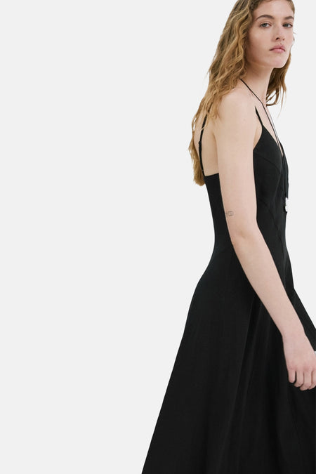 Robe noire de MANGO, coupe trapèze, avec fines bretelles et longueur midi.