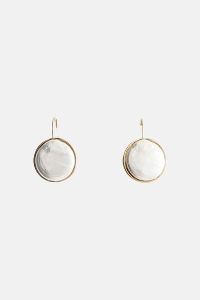 Boucles d'oreilles dorées de MANGO avec des disques nacrés circulaires suspendus aux crochets.