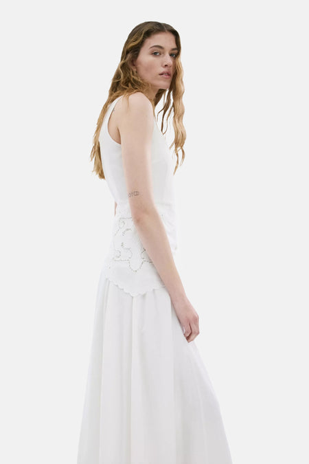 Robe écru de MANGO sans manches avec broderie ajourée à la taille et jupe fluide, portée de profil.