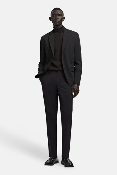 Black tailored suit pants with slim fit, worn with matching blazer, turtleneck, and loafers in full-length front view.