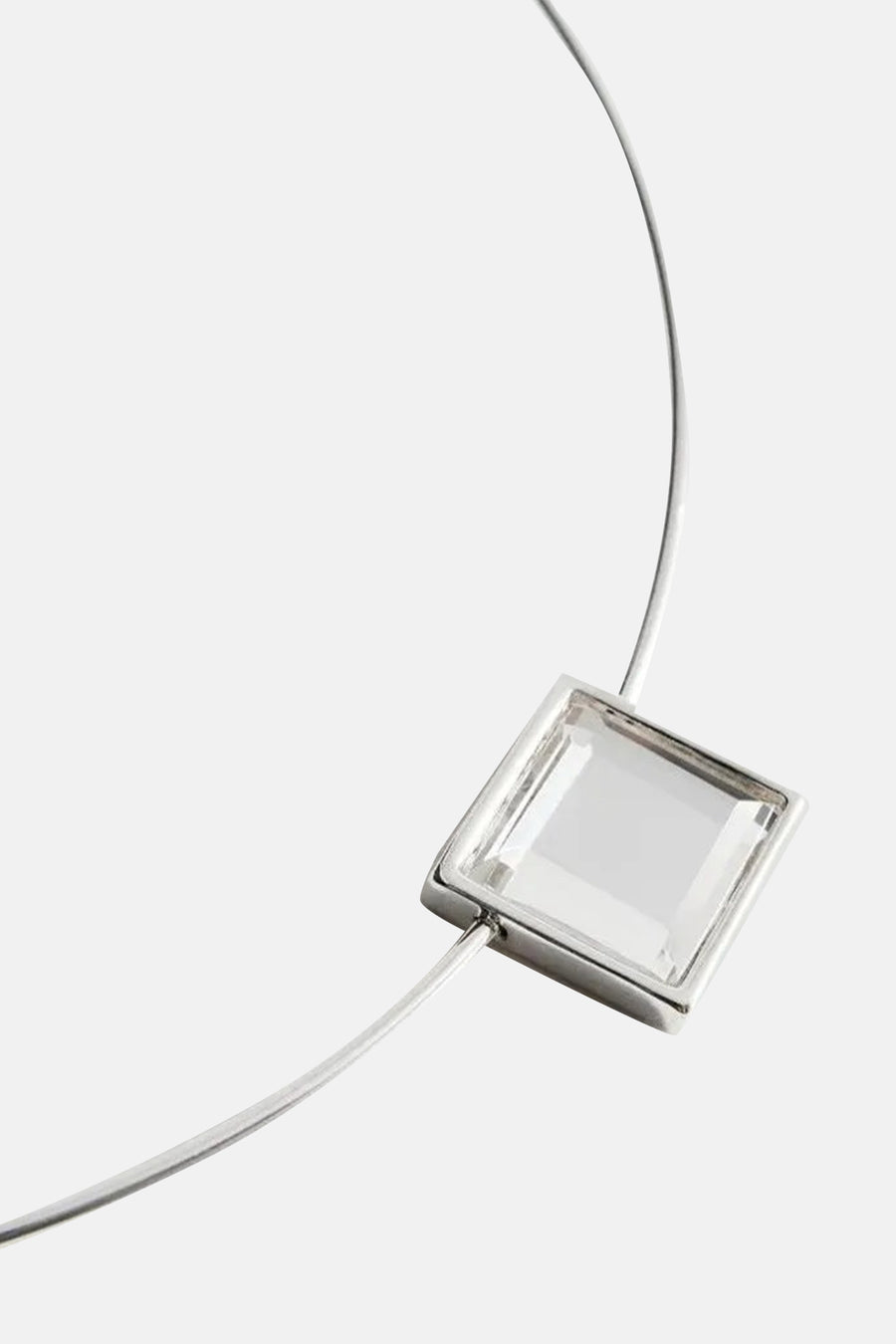 Korte zilveren halsketting van MANGO met een vierkante transparante oorbel.