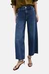 Jean large en denim bleu moyen de MANGO, porté avec un haut olive et des sandales minimalistes.