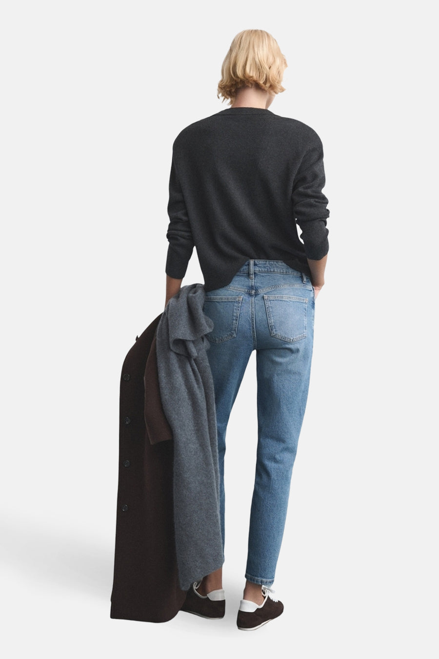 Jean Mom en denim bleu moyen de MANGO, porté avec un pull gris foncé et des chaussures marron.