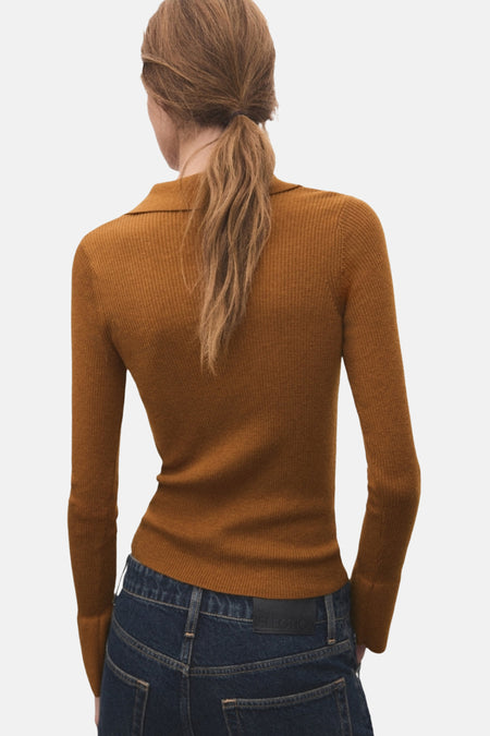 Pull à col rond marron de MANGO, porté avec un jean taille haute bleu foncé.