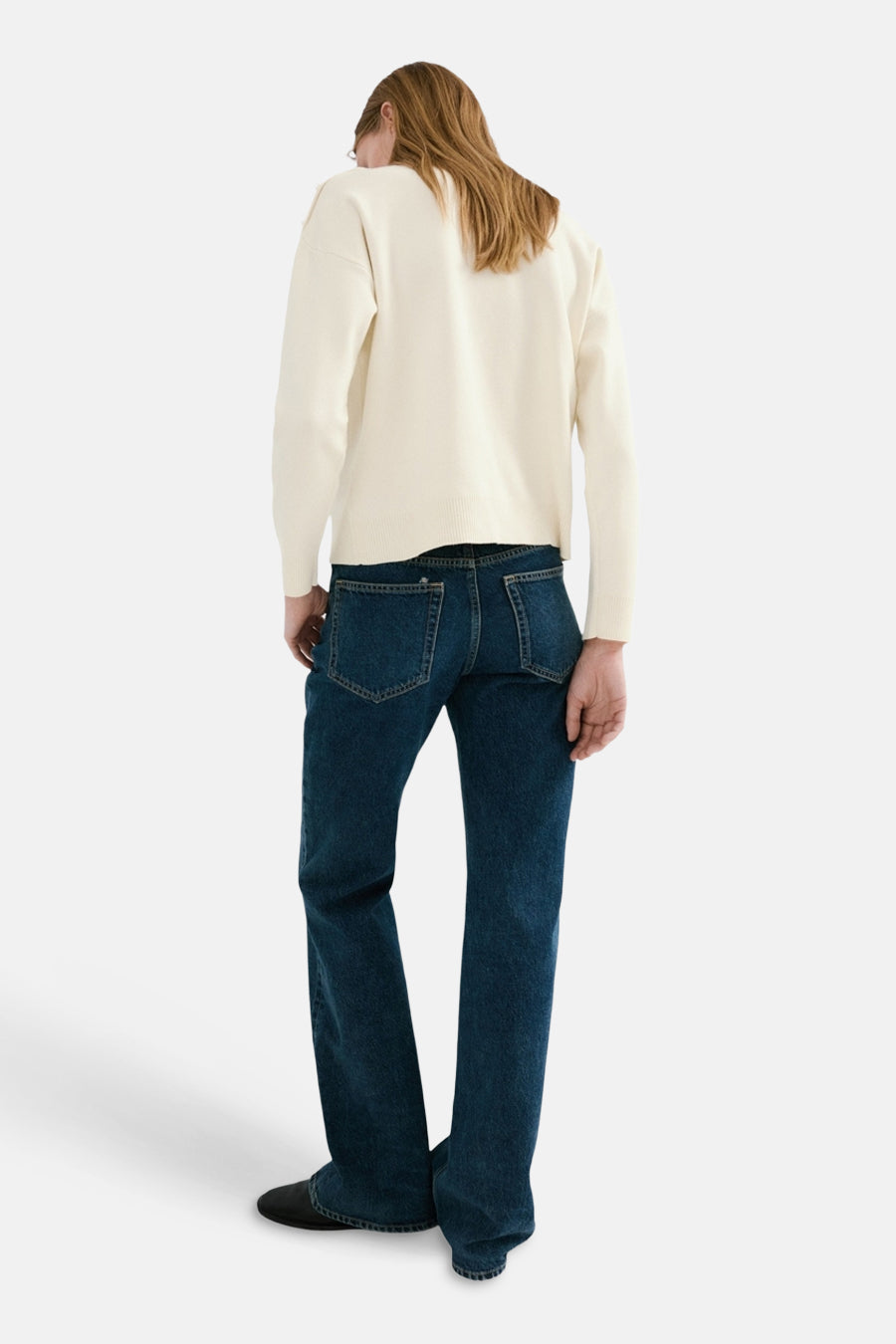 Pull à col rond écru de MANGO, porté avec un jean bleu foncé, vue de dos.