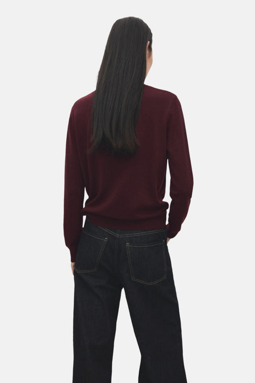 Pull à col rond bordeaux de MANGO, porté avec un jean foncé, vue de dos.