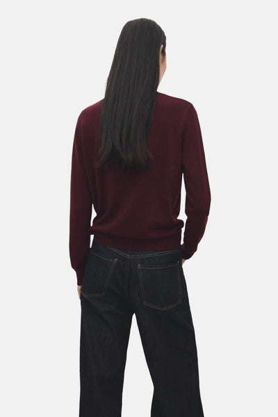 Pull à col rond bordeaux de MANGO, porté avec un jean foncé, vue de dos.
