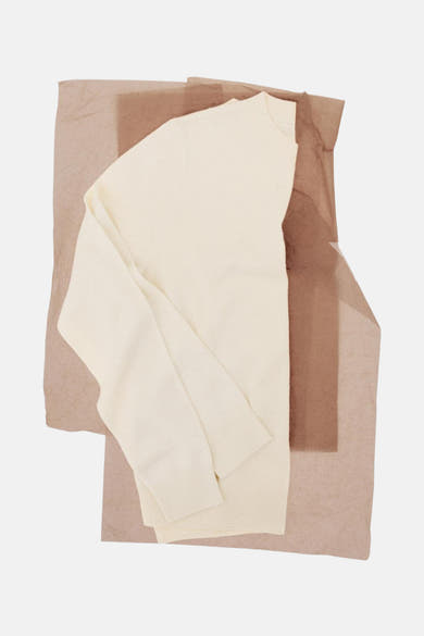Ecru ronde hals trui van MANGO, geplaatst op bruin en beige zijdepapier.