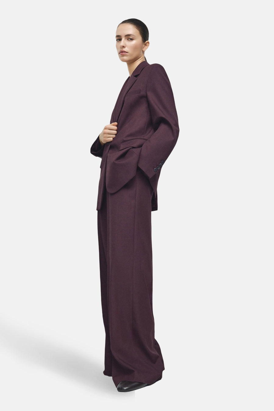 Bordeaux kostuumbroek van MANGO, wijde pasvorm en lange pijpen, gedragen met een bijpassende blazer.