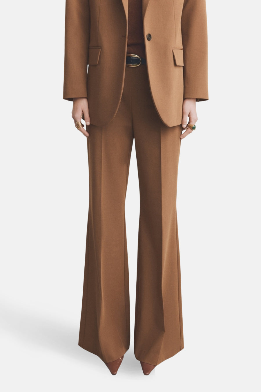 Pantalon évasé brun de MANGO, complété par une ceinture noire et des chaussures pointues marron.