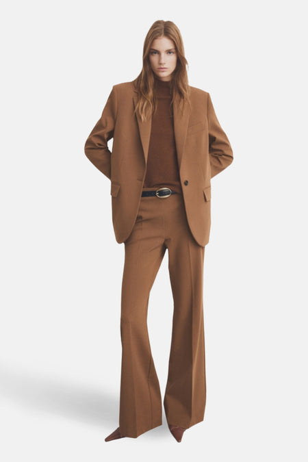 Pantalon évasé brun de MANGO, porté avec une ceinture noire et un blazer coordonné.