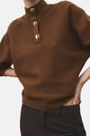 Pull à col roulé marron de MANGO avec trois boutons dorés sur le col.