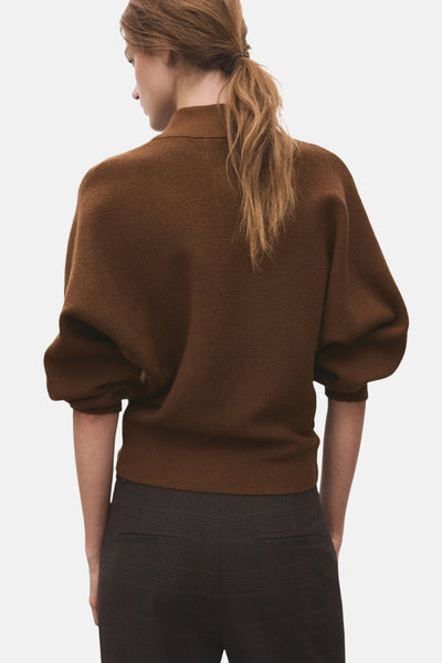 Pull à col roulé brun de MANGO, manches bouffantes, porté avec un pantalon à carreaux marron, vue de dos.
