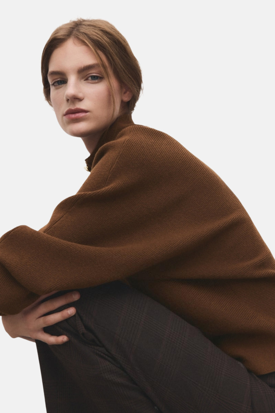 Pull à col roulé marron de MANGO, porté avec un pantalon à carreaux, en gros plan.