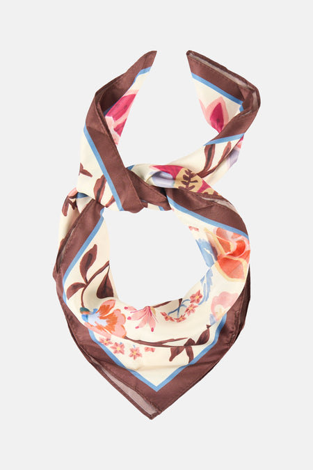 Foulard multicolore de MANGO, à motif floral et bordure marron avec une bande bleu clair, noué.

