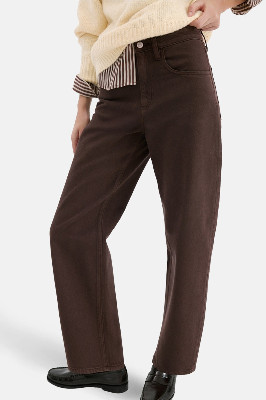 Jean coloré brun par MANGO, coupe droite, porté avec un pull jaune et des mocassins noirs.