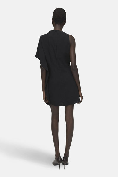 Robe noire asymétrique de MANGO, avec une épaule dénudée et coupe mini, vue de dos.