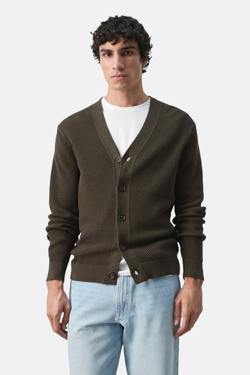 Gilet brun maille gaufrée de MANGO, porté sur un t-shirt blanc et un jean décontracté bleu clair.