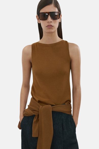 Top sans manches brun de MANGO, porté avec un pull noué à la taille et des lunettes de soleil.