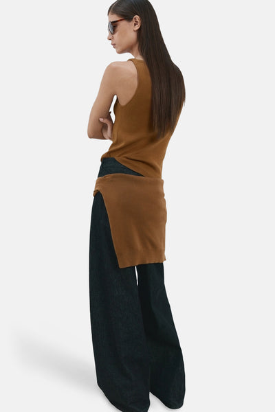 Top sans manches brun de MANGO, porté avec un pantalon large en jean foncé et des lunettes de soleil.